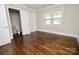 A bright bedroom featuring hardwood floors, a window for natural light, and an attached bathroom at 506 E Ridge St, Kings Mountain, NC 28086