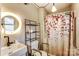 Cozy bathroom features modern sink, shelving, and accessible shower with tasteful floral curtain at 623 Spring Sw St, Concord, NC 28025