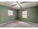 Empty bedroom showcasing natural light from two windows and dated carpet at 623 Spring Sw St, Concord, NC 28025