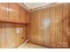 Functional laundry room with wooden cabinets, tiled floors, and wood paneled walls at 623 Spring Sw St, Concord, NC 28025