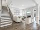Inviting living room with hardwood floors, staircase and stylish decor at 7206 Sumters Camp Trl, Fort Mill, SC 29707