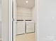 A functional laundry room with a side-by-side washer and dryer unit and wire shelving at 9021 Ramsford Ct, Mint Hill, NC 28227