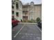 Exterior view of building with assigned parking and mature landscaping at 9709 Emerald Point Dr # 2, Charlotte, NC 28278