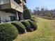 Lawn and shrubs surround the back porch with outdoor seating and manicured landscaping at 9709 Emerald Point Dr # 2, Charlotte, NC 28278