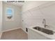 The laundry room features a stainless steel sink, countertop, and a window for natural light at 11016 Tyler Brook Ln # Oak0036, Mint Hill, NC 28227