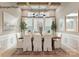 Elegant dining room with wood table, white chairs, wainscoting, and modern lighting fixture at 11020 Tyler Brook Ln # Oak0035, Mint Hill, NC 28227