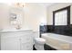 Bathroom featuring black marble wall accents, bright white fixtures and tub at 11121 Timber Hill Ct, Charlotte, NC 28226