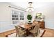Bright dining room features a wood table, rattan chairs, a large window, and elegant lighting at 11121 Timber Hill Ct, Charlotte, NC 28226
