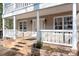 Inviting front porch with tile steps, white railings, and elegant lighting fixtures enhancing the home's entrance at 11121 Timber Hill Ct, Charlotte, NC 28226
