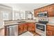 Kitchen with stainless steel appliances, countertop seating, sink with faucet and tile backsplash at 11130 Mccamie Hill Pl, Concord, NC 28025