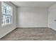 This is a spacious bedroom with a large window and grey hardwood floors at 120 Orville Rd, Statesville, NC 28677