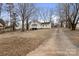 Long driveway leading to a charming two-story home with a spacious yard and mature trees at 1275 Rocky Creek Rd, Shelby, NC 28152