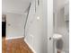 Hallway view featuring a staircase, wood flooring, and a partial view of a pedestal sink in the bathroom at 1275 Rocky Creek Rd, Shelby, NC 28152