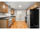Well-lit kitchen with wood cabinets, black appliances, and wood flooring at 1275 Rocky Creek Rd, Shelby, NC 28152