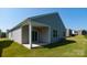Backyard featuring a covered patio, green grass, and the house's gray siding at 130 Woodhall Way, Troutman, NC 28166