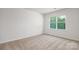 A bright bedroom featuring a window and neutral carpeting at 130 Woodhall Way, Troutman, NC 28166
