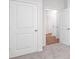 Bright hallway featuring neutral walls, plush gray carpet, and a series of white paneled doors at 130 Woodhall Way, Troutman, NC 28166