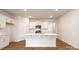 Modern kitchen with stainless steel appliances, white cabinets, a large kitchen island and hardwood floors at 130 Woodhall Way, Troutman, NC 28166