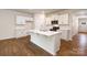Bright and airy kitchen featuring a center island, white cabinetry, stainless appliances and hardwood floors at 130 Woodhall Way, Troutman, NC 28166