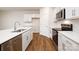 Close up of a modern kitchen featuring stainless steel appliances, white cabinets, and hardwood floors at 130 Woodhall Way, Troutman, NC 28166