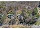 Aerial view of a house and lot nestled in a wooded area with nearby residential homes at 15314 Logan Grove Rd, Charlotte, NC 28227