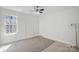 Minimalist bedroom with neutral walls, a gray rug, a ceiling fan, and a sunny window at 15314 Logan Grove Rd, Charlotte, NC 28227
