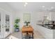 Bright dining area featuring a wooden table, bench seating, and natural light from the doors to the backyard at 15314 Logan Grove Rd, Charlotte, NC 28227