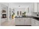Open kitchen with a view of the breakfast nook, living area, and outdoor space through French doors at 15314 Logan Grove Rd, Charlotte, NC 28227
