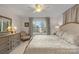 Bright bedroom features a ceiling fan, large window, dresser, and bedside tables with lamps at 1665 Sherwood Ct, Sherrills Ford, NC 28673
