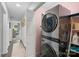 Hallway laundry room features stacked washer/dryer unit, open door to living room, and wood floors at 1665 Sherwood Ct, Sherrills Ford, NC 28673