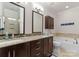 Well-lit bathroom with double sinks, granite countertops, and a soaking tub at 18409 Harborside Dr, Cornelius, NC 28031