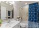 A well-maintained bathroom with blue shower curtain, vanity, mirror and natural light at 18409 Harborside Dr, Cornelius, NC 28031