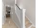 View of bright hallway with tiled floor leading to a staircase with a white banister and carpeted steps at 18409 Harborside Dr, Cornelius, NC 28031