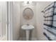 This well-lit powder room showcases a pedestal sink, a stylish round mirror, and modern fixtures at 18409 Harborside Dr, Cornelius, NC 28031