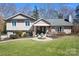 Charming home featuring a manicured lawn, inviting front porch, and beautiful water fountain centerpiece at 19320 Davidson Concord Rd, Davidson, NC 28036