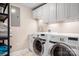 Bright laundry room with modern washer and dryer units and white cabinets at 19320 Davidson Concord Rd, Davidson, NC 28036