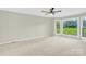 Spacious bedroom with neutral carpet, ceiling fan, and large windows overlooking the backyard at 2041 Jefferson Ave, Gastonia, NC 28056