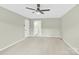 Bright bedroom featuring neutral walls, carpet, a ceiling fan, and an ensuite bathroom at 2041 Jefferson Ave, Gastonia, NC 28056