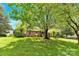 This traditional home has a spacious front lawn shaded by mature trees in a lush yard at 2041 Jefferson Ave, Gastonia, NC 28056