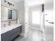 Modern bathroom featuring blue-gray vanity, mosaic backsplash, and large window for plenty of natural light at 2526 Fort St, Charlotte, NC 28205