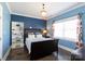 This bedroom has blue walls, wood floors, white trim, a shelf, and a window with patterned curtains at 2526 Fort St, Charlotte, NC 28205