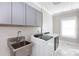 Functional laundry room equipped with modern washer, dryer, stainless steel sink and ample cabinet storage at 2526 Fort St, Charlotte, NC 28205