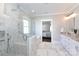 Bright bathroom boasts a luxurious soaking tub, glass shower enclosure, marble surround and dual vanity at 2526 Fort St, Charlotte, NC 28205