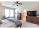 Sunlit bedroom features neutral walls, stylish dressers, a chair and ceiling fan at 2551 Barry St, Charlotte, NC 28205