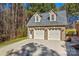 Three-car garage and outbuilding with brick facade, white garage doors, and natural surroundings at 279 Farm Estates Dr, Rockwell, NC 28138