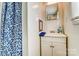 A clean bathroom with a white vanity, mirror, and a blue shower curtain at 305 S Clay St, Gastonia, NC 28052