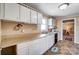 Practical kitchen layout with white cabinets, speckled countertops, and access to the living room at 305 S Clay St, Gastonia, NC 28052
