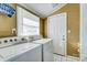 Bright laundry room with white appliances, a window for natural light and ceramic tile floor at 305 S Clay St, Gastonia, NC 28052