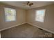 Bright bedroom with two windows, neutral walls, carpet, and a classic ceiling fan at 3412 1St Avenue Nw Cir, Hickory, NC 28601