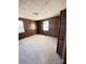 Cozy bedroom featuring classic wood paneling, neutral carpet, and two bright windows at 3412 1St Avenue Nw Cir, Hickory, NC 28601